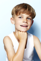 Portrait of young boy in vest, studio.