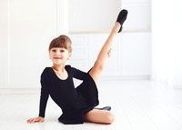 beautiful young girl doing stretching exercises at ballet school